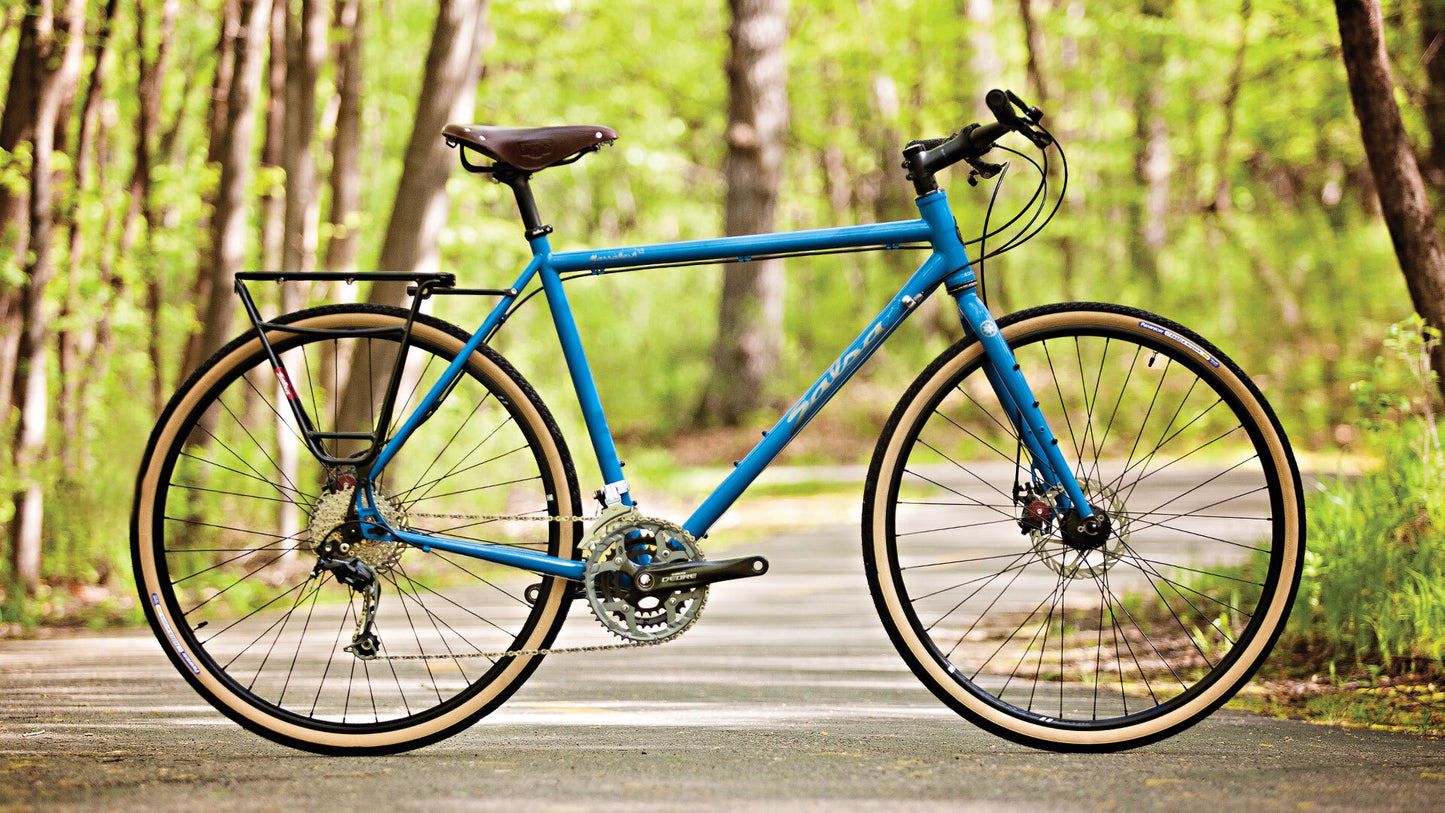 Salsa Marrakesh Deore Flat Bar bike blue color side view outside on bike path