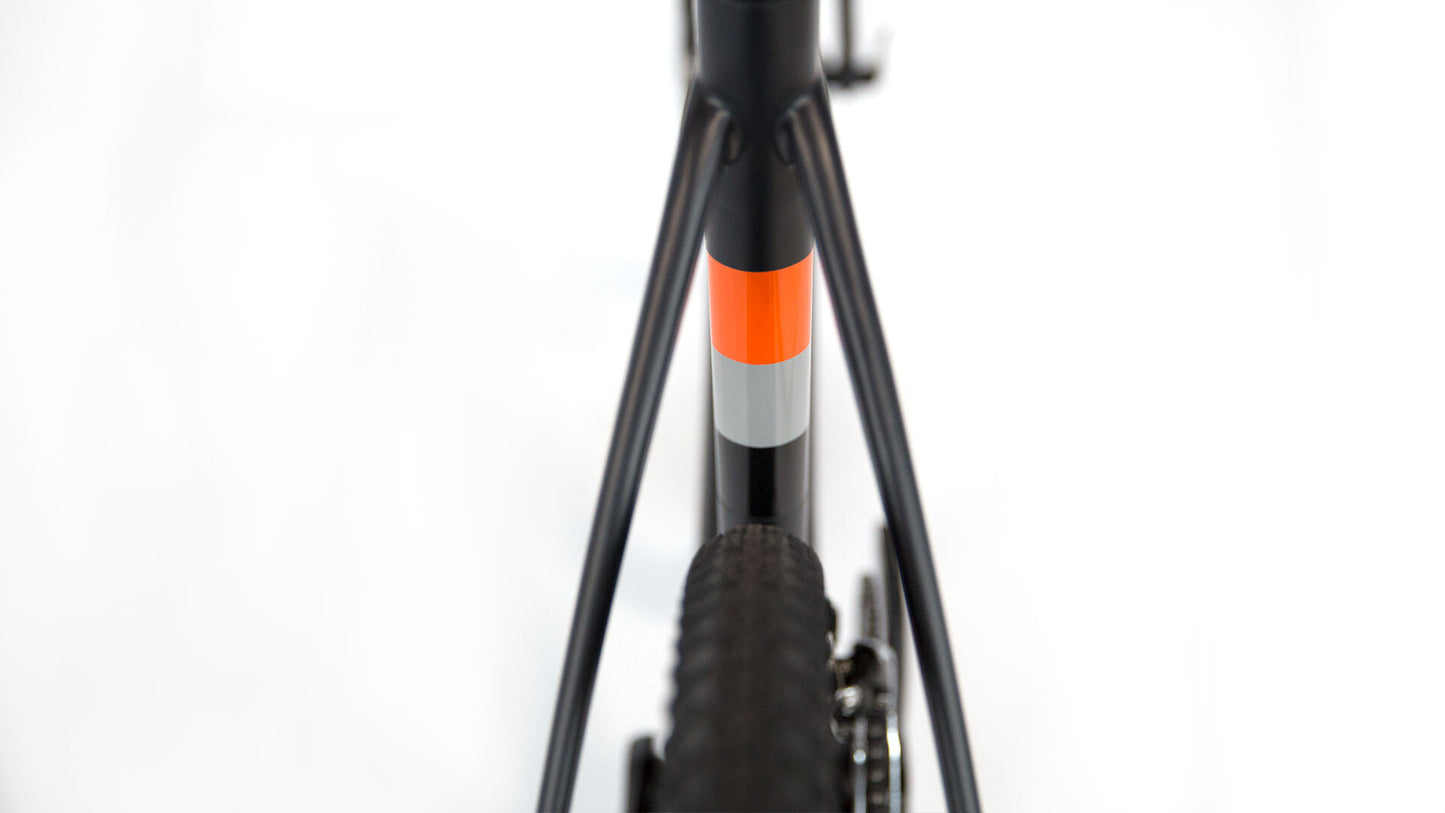 Close-up of a bicycle frame with orange and gray accents on a white background