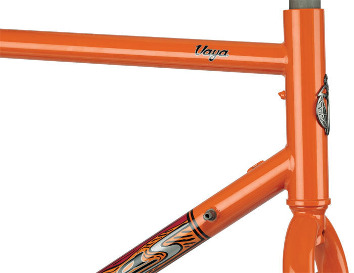 Close-up of an orange bicycle frame with 'Vaya' branding on a white background