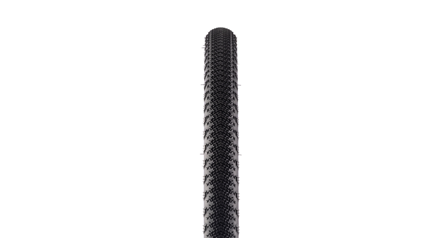 A close-up vertical view of a black bicycle tire tread against a solid white background.