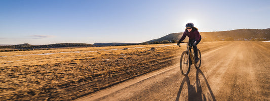 Krystal Salvents riding bike on desert gravel road on clear day