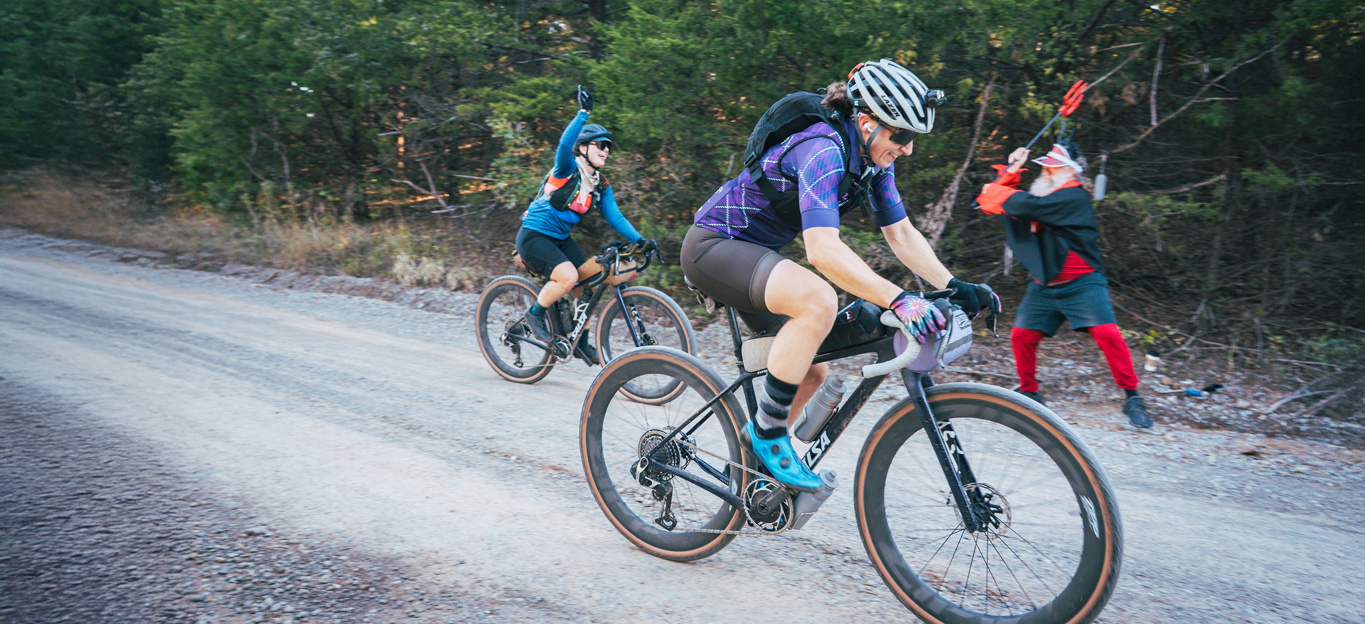 Three people riding bicycles on a road with trees in the background