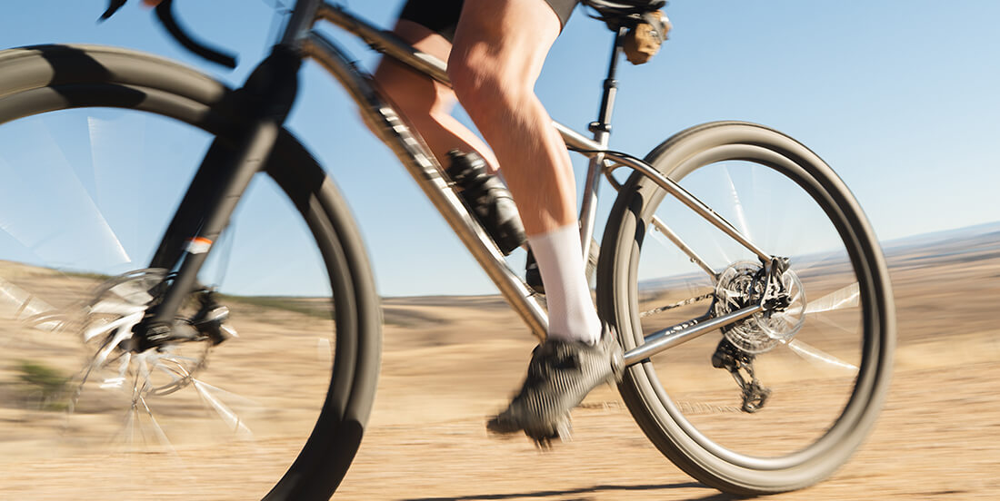 Person riding a bicycle on a road with a clear blue sky
