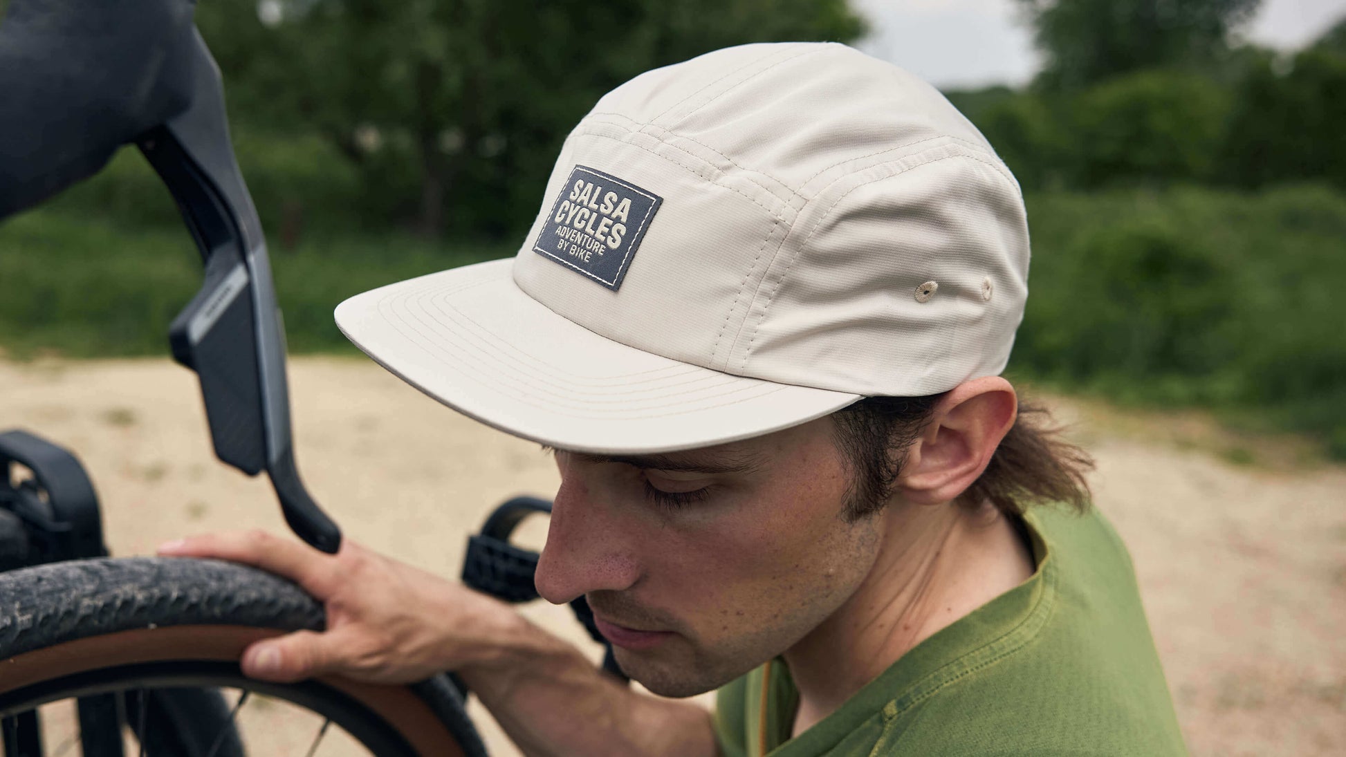 Rider wears the Salsa Adventure by Bike Hat in cream while unloading a bike from a car rack