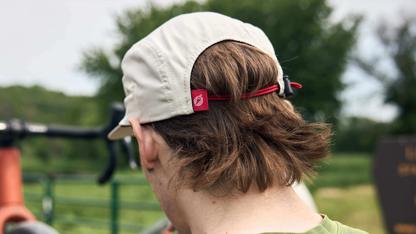 The back of a rider's head is shown while wearing the Salsa Adventure by Bike Hat in cream.