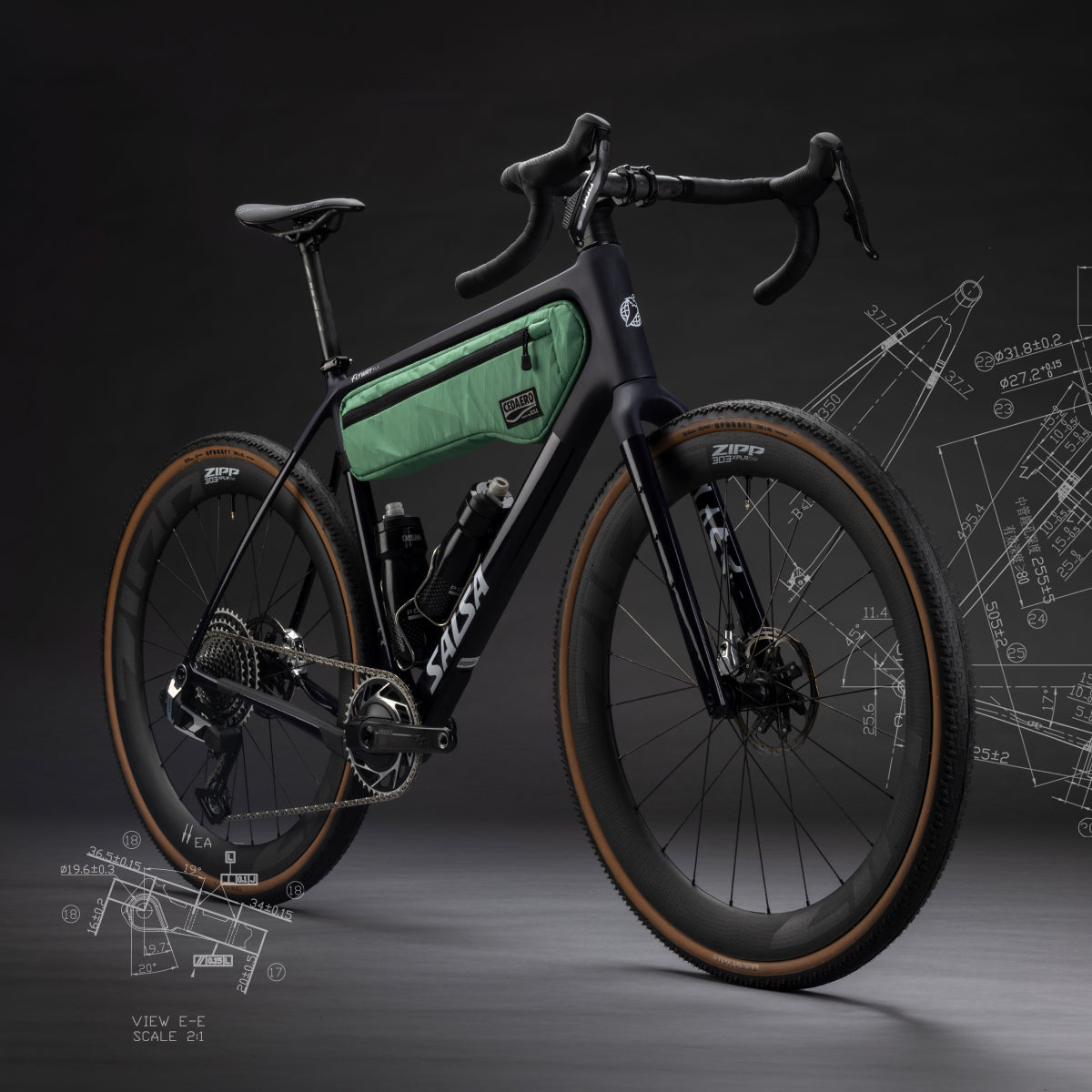 A black Salsa Flyway gravel bicycle with a green frame bag, shown on a dark studio background with technical blueprint graphics.