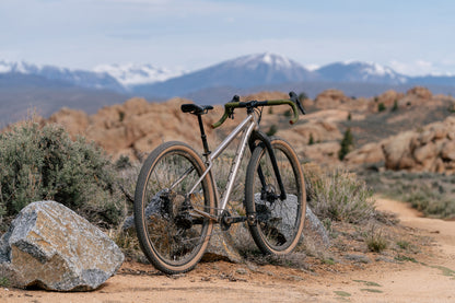 Salsa Fargo 32 Titanium bike on a dirt trail with mountains in the background