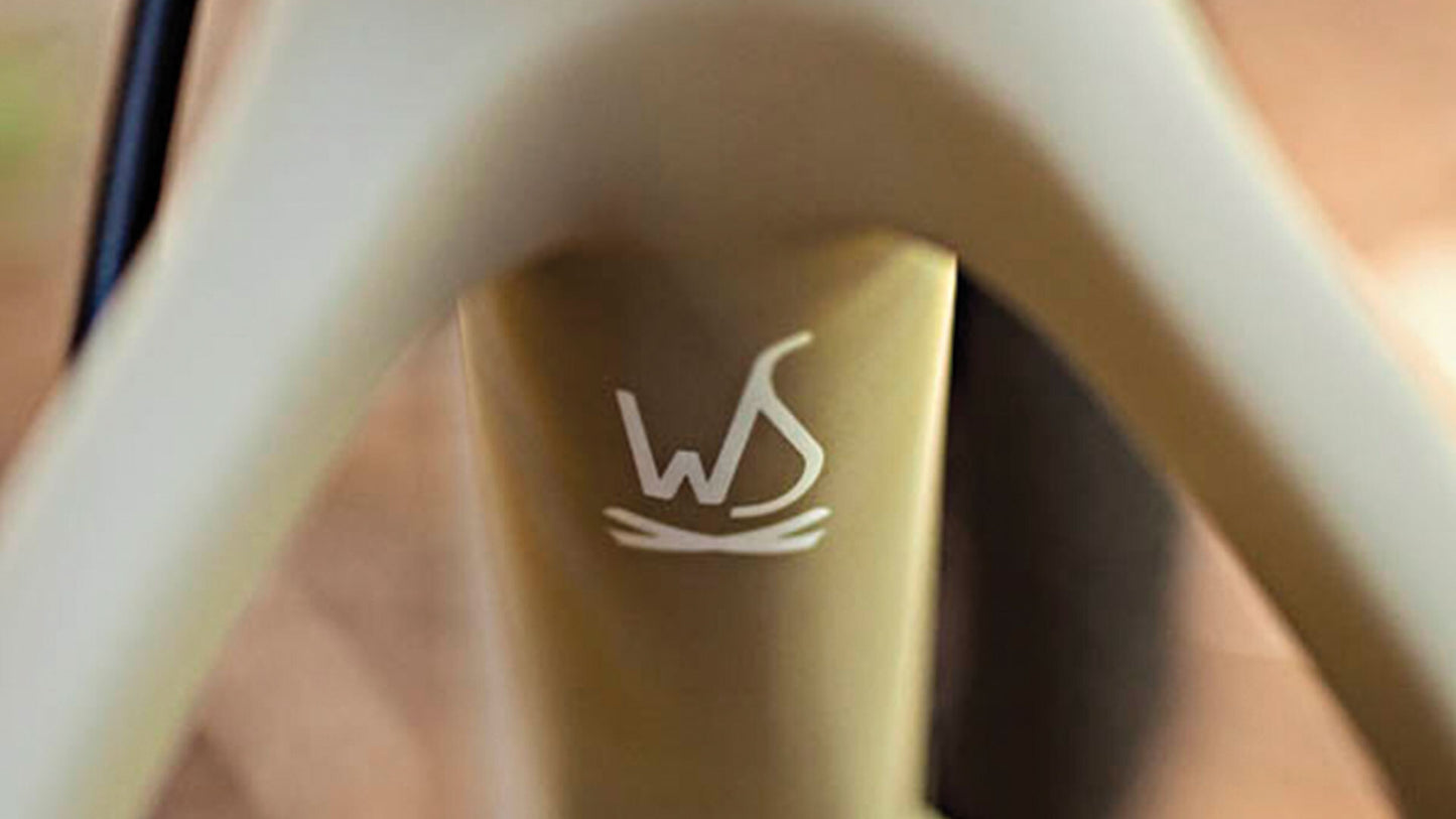 Close-up of a white bicycle handlebar with a gold accent and 'WS' logo.