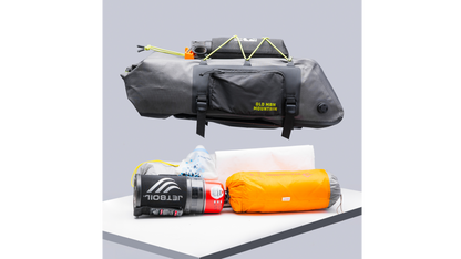 An Old Man Mountain Atlas Rack Pack, shown above all the gear that can fit inside, such as a canteen and sleeping bag.