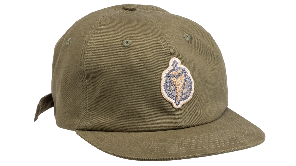 An olive green flat-brim baseball cap featuring a circular embroidered patch on the front with a pepper
